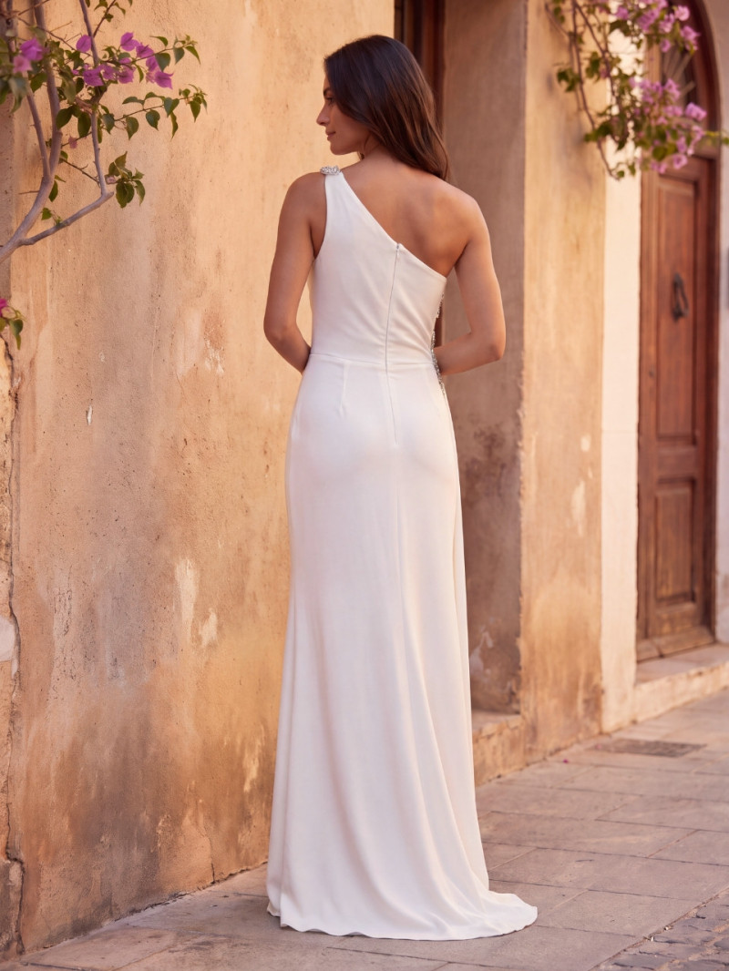 Vista trasera del vestido de novia Celeste largo blanco con escote asimétrico y falda fluida